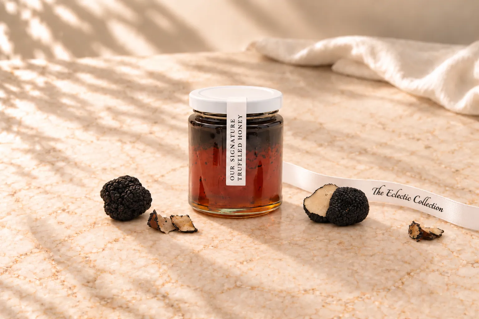 A jar of our signature truffled honey beside black truffles