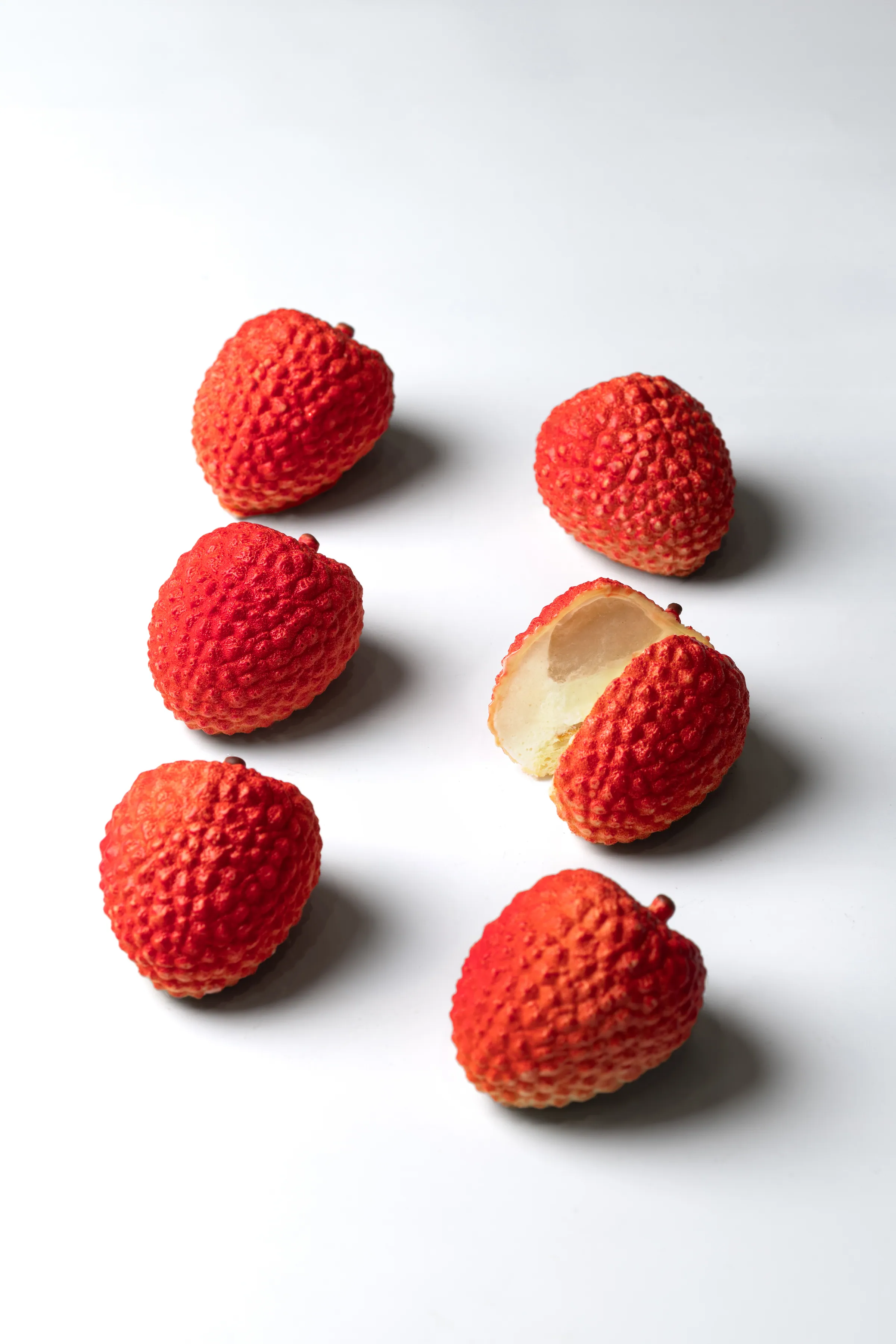Six Lychee pâtisserie, one cut open